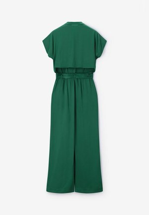 Donkergroene jumpsuit met wijde pijpen, korte mouwen, tailleband en cropped overlay top, van achteren getoond op een witte achtergrond.