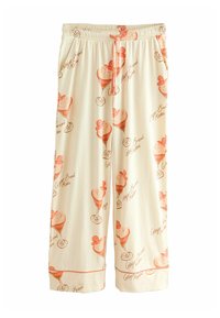 Cream-colored wide-leg pants featuring an ice cream sundae print in orange tones with text, exhibiting a soft textile and elastic waistband.