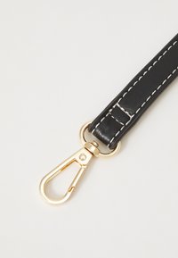 Czarny pasek z faux skóry z białym przeszyciem, z złotym metalowym zapięciem zapewniającym pewne mocowanie. Gładka tekstura z eleganckim designem.