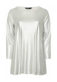 Silver metallisk långärmad topp med rundad halsringning och avslappnad passform. Tyget har en ribbad yta och en glansig finish.