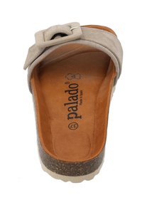 Sandale à talon en suède beige avec un accent boucle. Semelle intermédiaire en liège et semelle intérieure en cuir marron doux, avec des détails en logo embossé.