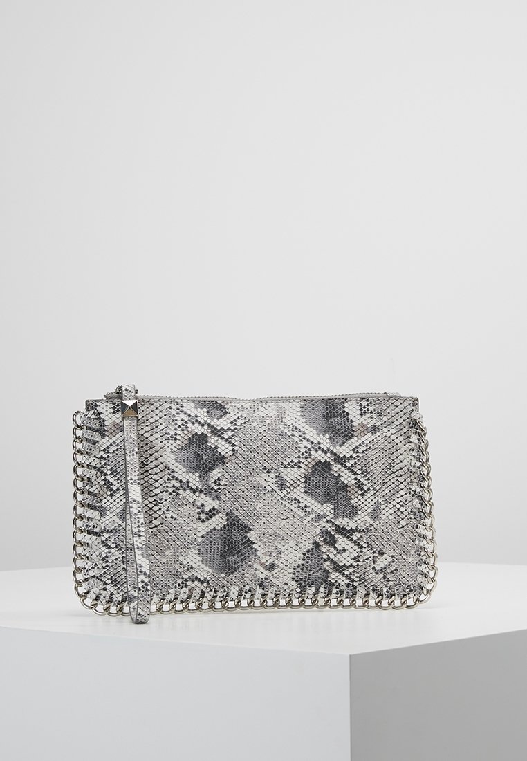 Pochette à motif peau de serpent gris et noir, garnie d'une chaîne argentée et dotée d'une sangle pour poignet, présentée sur un socle blanc sur fond gris.