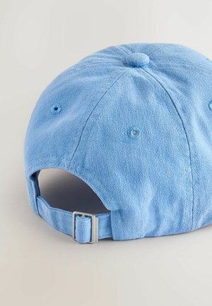 Căciula din denim albastru deschis are un crown rotund, un buton acoperit cu țesătură, orificii de ventilație și o curea ajustabilă din metal la spate.