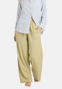 Pantalon large à rayures en tissu vert olive clair avec des lignes verticales, coupe ample, doté d'une ceinture élastique et de poches latérales.