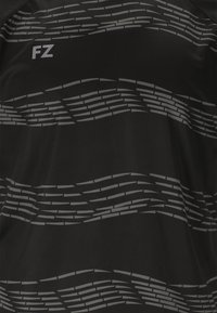 Musta urheilupaita, jossa on harmaan aaltoilukuviot ja modernilla fontilla kirjoitetut kirjaimet "FZ". Valmistettu sileästä ja kevyestä materiaalista.