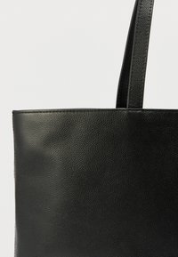 Černá kožená taška přes rameno s texturovaným povrchem, obdélníkovým tvarem a dvěma pevnými uchy. Jednoduchý design bez viditelného kovového vybavení nebo ozdob.