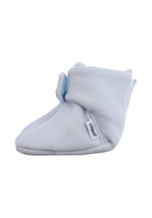 White cotton booties with a soft texture, featuring a velcro closure and small fabric tabs. Brand label visible on the side.