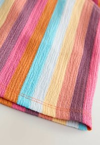 Tissu rayé présentant des lignes horizontales dans des teintes de rose, orange, violet, bleu et jaune. Surface texturée avec des détails de couture visibles.
