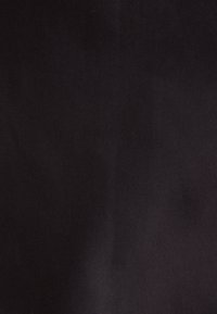 Tessuto nero con una superficie liscia, uniformemente colorato senza motivi visibili, pieghe o dettagli hardware. Ideale per vari utilizzi.