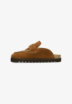 Chaussure à enfiler en daim marron avec un devant arrondi, deux accents de sangle, une semelle texturée et un détail de talon en liège. Dispose d'une doublure douce pour le confort.