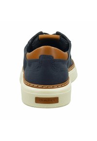 Navy canvas sneaker with brown leather accents, cream rubber sole, and contrasting stitching. Features GANT logo on the back.