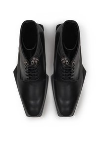 Schwarze Leder-Ankleboots mit einem eleganten, kantigen Design, ausgestattet mit metallischen Details und Schnürsenkeln. Glatte Textur und spitz zulaufende Schuhform.