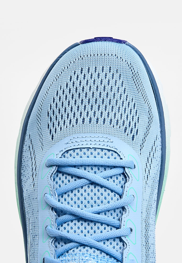Chaussure de sport bleu clair avec une tige en maille respirante, un design texturé, des lacets contrastants et une semelle en caoutchouc flexible.
