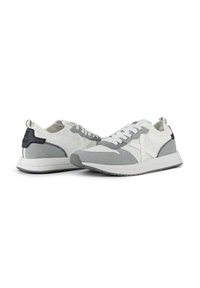 Zapatillas con una parte superior de malla blanca y acentos de ante gris, que cuentan con cordones blancos, un cuello texturizado y una suela de goma.