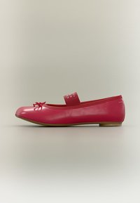 Chaussure ballerine plate rouge avec un petit nœud sur l'orteil et une bride élastique sur le cou-de-pied sur un fond uni.