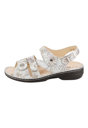 Sandale blanche avec motif de feuilles beige, trois brides réglables, semelle intérieure rembourrée et semelle noire.