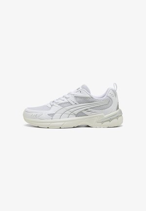 Baskets de sport blanches avec panneaux en mesh, semelle texturée, languette de traction au talon et fermeture à lacets, vues de profil sur fond blanc.