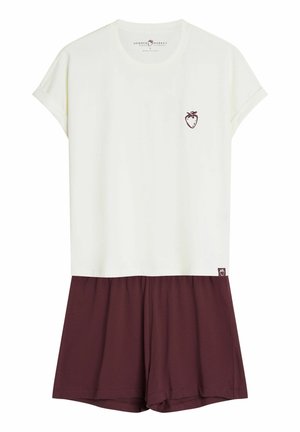Biały top z krótkim rękawem z małą ikonką truskawki, połączony z luźnymi bordowymi szortami, casualowy strój letni.