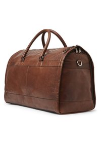 Sac de voyage en cuir marron avec un design structuré, deux poignées et une fermeture éclair. Présente une texture avec un grain visible et des détails de couture.