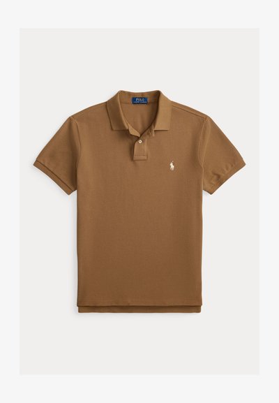 Polo marron en coton texturé, avec une patte de boutonnage à deux boutons et un petit logo brodé sur la poitrine gauche. Manches courtes.