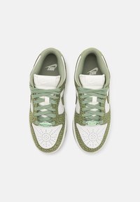 Buty sportowe Nike z zieloną, fakturowaną cholewką w wzór panterki, białymi akcentami i zielonymi sznurowadłami, z perforowanym detalem na czubku.