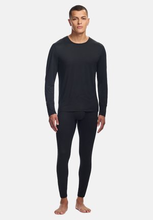 Zwarte langhel shirt en aansluitende leggings van soepel, rekbaar materiaal. Het ontwerp is eenvoudig, zonder zichtbare patronen of accenten.