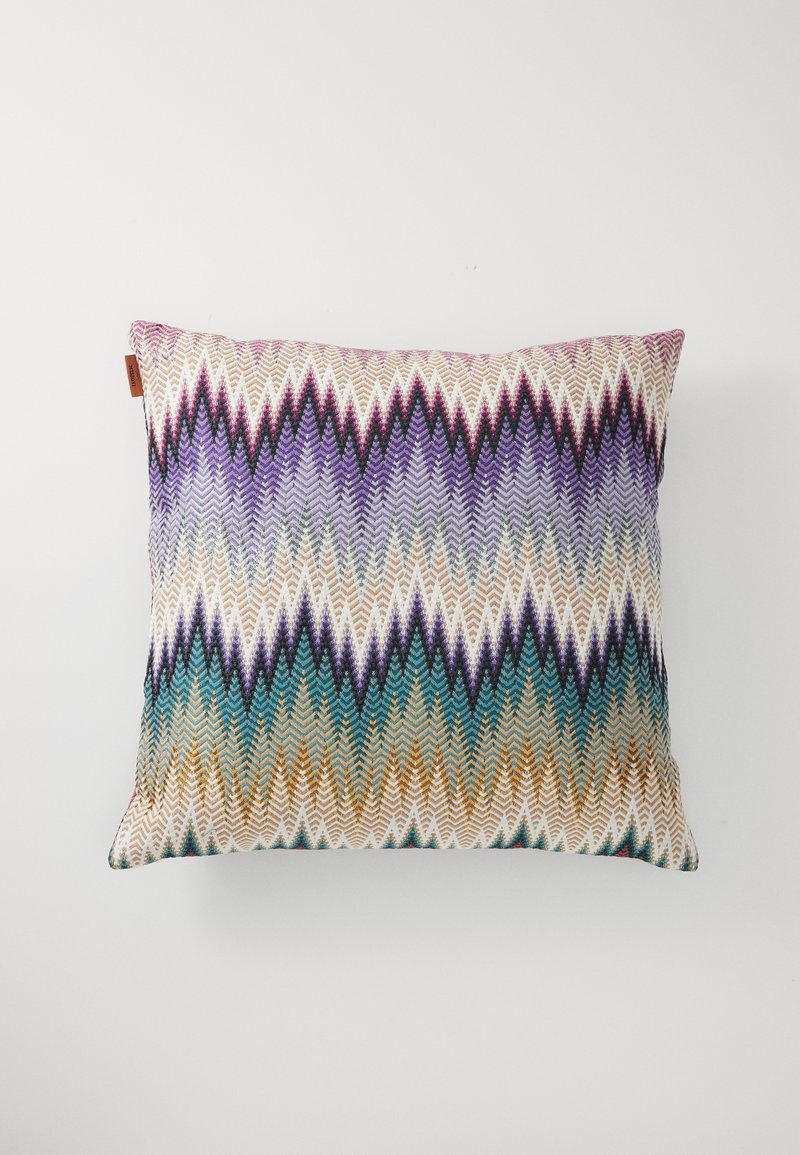 Patterned rectangular pillow with zigzag design in purple, teal, and gold. Fabric texture appears woven with multicolored geometric accents.