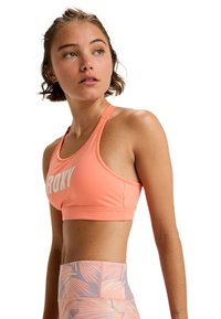 Koraalrode sport-bh met witte "ROXY" branding, racerback ontwerp en een gladde textuur. Gecombineerd met gestreepte hoge taille legging met bladmotieven.