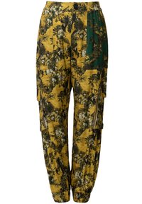 Cargo broek van gele stof met groene en zwarte bloemenpatronen, voorzien van zijzakken, een elastische tailleband en een knoopsluiting.