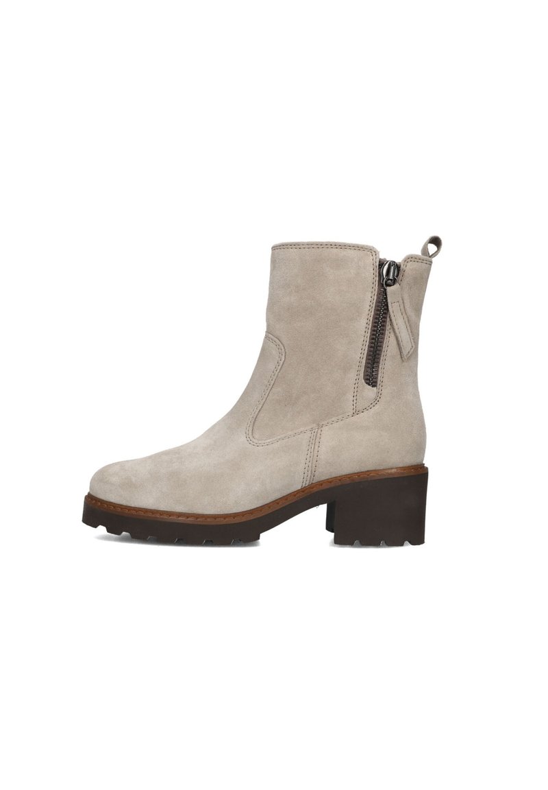 Beige suède enkellaars met een blokhak, zijrits en een getextureerde rubberen zool. Voorzien van gestikte accenten en een trekband aan de achterkant.
