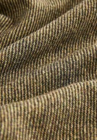 Texturiertes Gewebe in Erdtönen, mit abwechselnd dicken und dünnen Streifen in Braun, Grün und Beige. Weiche Wollmischung mit einem warmen Gefühl.