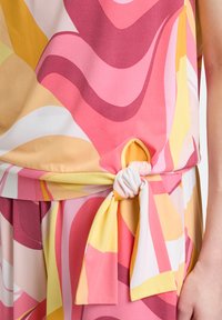 Kolorowa bluzka z gładkiego, zwiewnego materiału w odcieniach różu, żółci i burgundu, z wiązaniem w talii.
