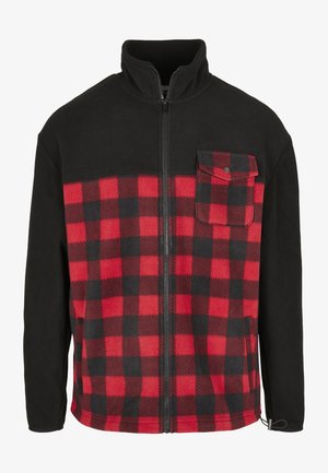 Svart och röd rutmönstrad fleecejacka med dragkedja, hög krage och ficka på vänster bröst. Har långa ärmar och en mjuk textur.