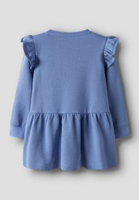 Mėlyna, ilgomis rankovėmis suknelė su rauktomis peties detalėmis, suvarstytu liemeniu ir platėjančia sijonu; pagaminta iš minkštos, tekstūruotos medžiagos.