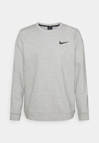 Sudadera de manga larga Nike de color gris claro con cuello redondo y logo de swoosh negro en el lado izquierdo del pecho.