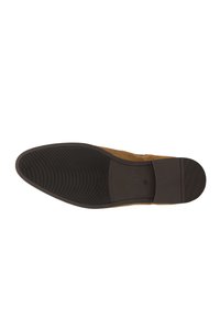 Braune Wildlederschuhe mit einer glatten Gummisohle. Die Unterseite ist mit horizontalen Rillen versehen, um Halt zu bieten, und ist mit der Größe "42" geprägt.