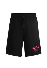 Czarne spodenki sportowe wykonane z mieszanki bawełny, z elastycznym pasem w gumkę i sznurkiem do regulacji oraz różowym nadrukiem logo na lewej nodze.