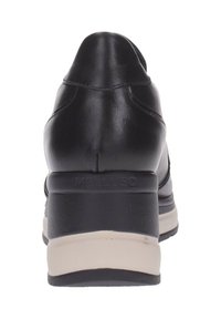 Zapato de cuero negro con punta redondeada y tacón de cuña. Presenta acentos moldeados y una suela de goma beige para contraste. Nombre de la marca "Melluso" en relieve.