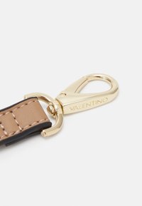 Gold metal clasp attached to a brown leather strap with visible stitching. The clasp features the engraved brand name "Valentino."
