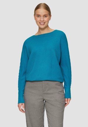 Turquoise geribd sweater met een boot-halslijn en lange mouwen, gecombineerd met grijze broeken. De sweater heeft een relaxte pasvorm en een gestructureerde stof.