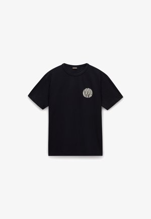 Tricou din bumbac negru, cu mâneci scurte, guler rotund și un logo circular alb în zona stângă a pieptului. Textură netedă, design casual.