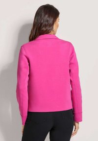 Fuchsia roze sweatshirt jack met een kraag, lange mouwen en geribbelde manchetten; heeft een zachte textuur en nette stiksels.