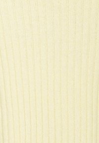 Tessuto a maglia a coste di colore giallo chiaro con strisce verticali, che presenta una superficie morbida e testurizzata. Nessun motivo o dettaglio hardware visibile.
