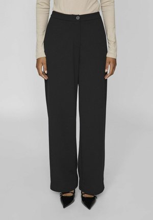 Black wide-leg trousers with a smooth texture, featuring a front button closure and no visible patterns. Paired with pointed black shoes.