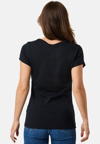 Black short-sleeve t-shirt with a rounded neckline, smooth textile finish, and a fitted design, paired with blue denim jeans.