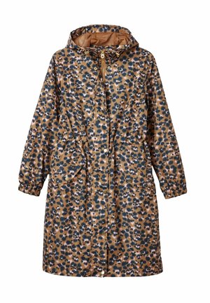 Wasserfester Mantel mit Leopardendruck, Reißverschluss und Druckknopfverschluss, zwei frontalen Taschen und einer verstellbaren Kapuze. Kombiniert mit schwarzen Hosen und braunen Schuhen.