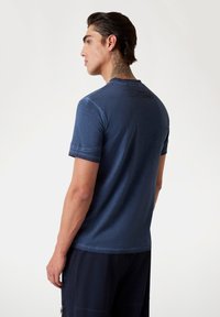 Marineblå kortærmet T-shirt med rund halsudskæring, der har en subtil tekstur og trykte detaljer på bagsiden. Behagelig pasform.