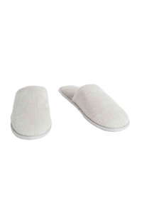 Zapatillas de casa de color gris claro, hechas de una tela suave y texturizada, con la punta cerrada y la parte trasera abierta. Suela de goma blanca con un diseño minimalista.