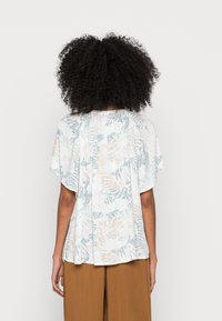 Lätt kortärmad topp i mjuk textil, med en flerfärgad botanisk tryck i pastellfärger, lös och luftig passform och veck bak.