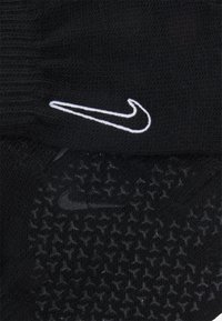 Gants Nike noirs avec un design en maille texturée, ornés d'un logo Nike swoosh blanc bien en vue sur la partie supérieure.